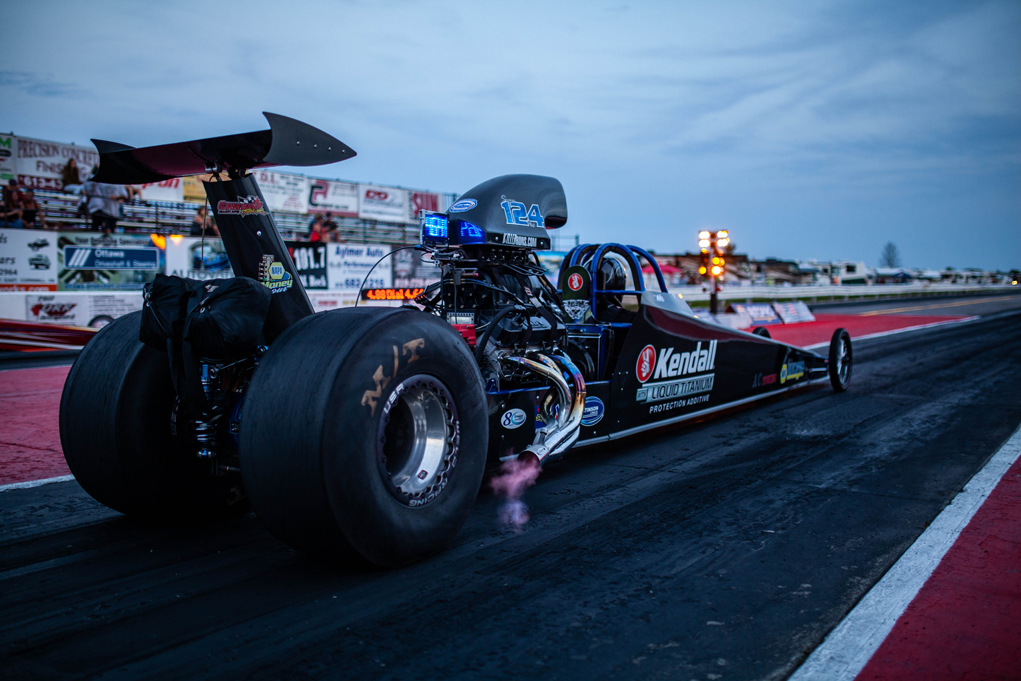 Le coureur ontarien Mike Oglvie a bord de son dragster ''Small Block Mopar'' muni d'un blower lors d'un départ au Super Tour de Luskville. Remarquez les flammes qui sortent des échappements! © John Chambers